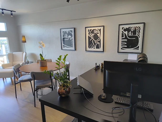 Sala de espera com obras de arte e mesa redonda