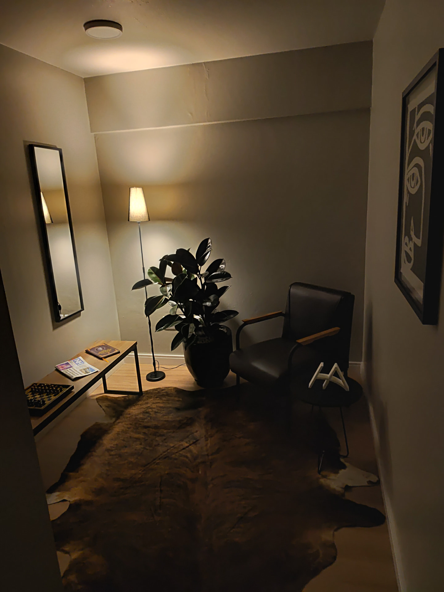 Recepção do escritório com poltrona, planta e monograma HA